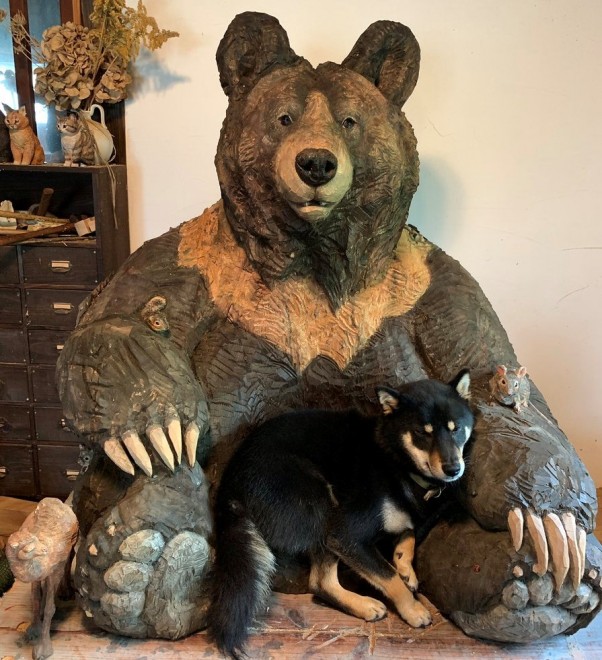 大きなクマの彫刻と共に育った犬”がSNSで反響、「成長して体がはみ出ても、そこが居場所に」 | ORICON NEWS