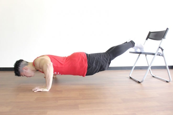 2．肘を深く曲げて床に近づけるように体を落とす。腰は真っ直ぐの状態を保つ。1～2の動きを繰り返す。