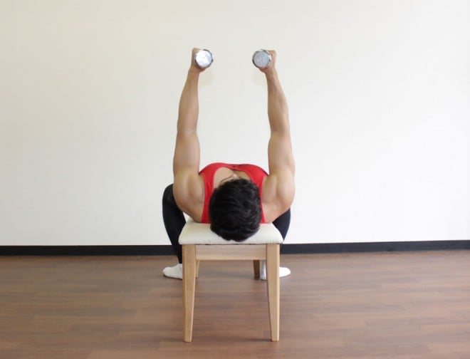 1．ベンチに仰向けになり、両手にダンベルを持つ。腕を真っ直ぐに伸ばしながら、肩の真上にダンベルを持ち上げる。胸を張り、手のひらが向かい合うパラレルグリップで構える。