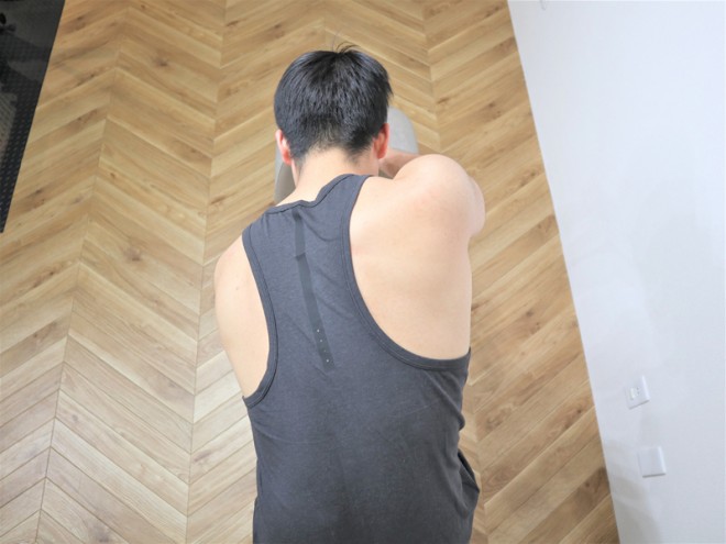 背筋を鍛える際の広背筋と大円筋を鍛えるダンベルワンハンドローイングの動作（拡大１）　ダンベルを下におろしている状態。肩甲骨が広がりストレッチしているのを感じるように行う。