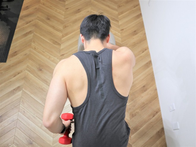 背筋を鍛える際の広背筋と大円筋を鍛えるダンベルワンハンドローイングの動作（拡大２）　ダンベルを上に持ち上げ、肩甲骨を寄せる。広背筋が収縮していることを感じるように行う。