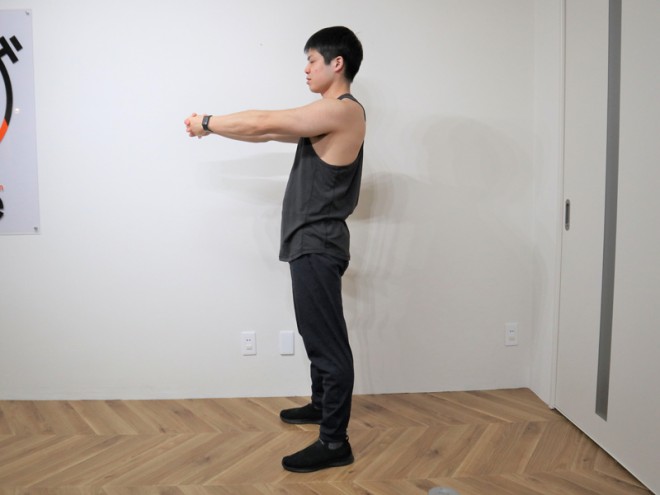 背筋を鍛えた後に行うストレッチ　両手を胸の前で組み腕を伸ばす。