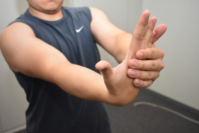 1. 右肘を伸ばして左手で右手の甲を持つ 2. 手首を手のひら側に曲げる