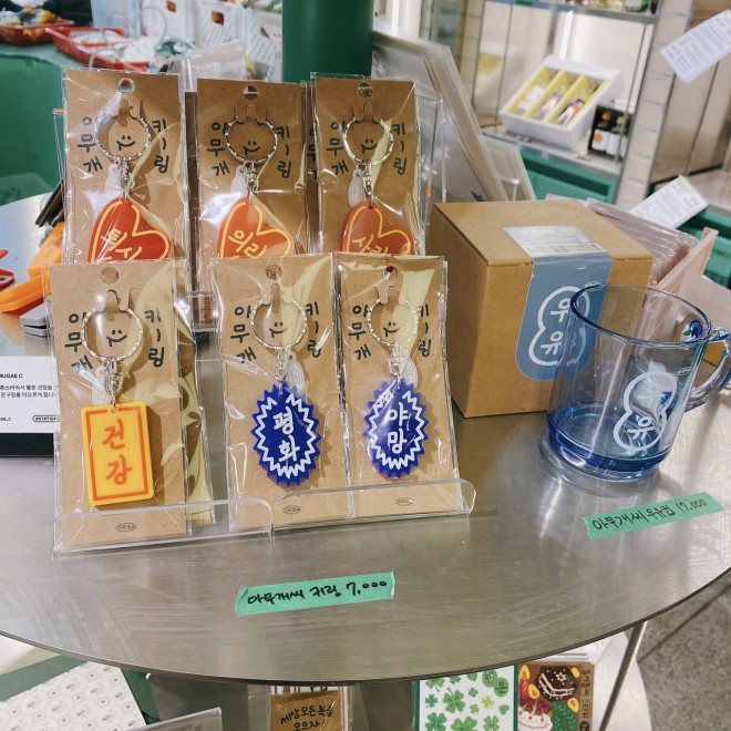 귀여운 한글 열쇠고리(약 700엔) 왼쪽부터 'Health', 'Peace', 'Ambition'', 오른쪽 컵(약 1,700엔)에도 'Health', 'Peace', 'Ambition'이라는 글자가 새겨져 있습니다. ``우유(우유).''