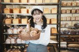 オリジナルレシピのパンを手に笑顔の休井美郷 